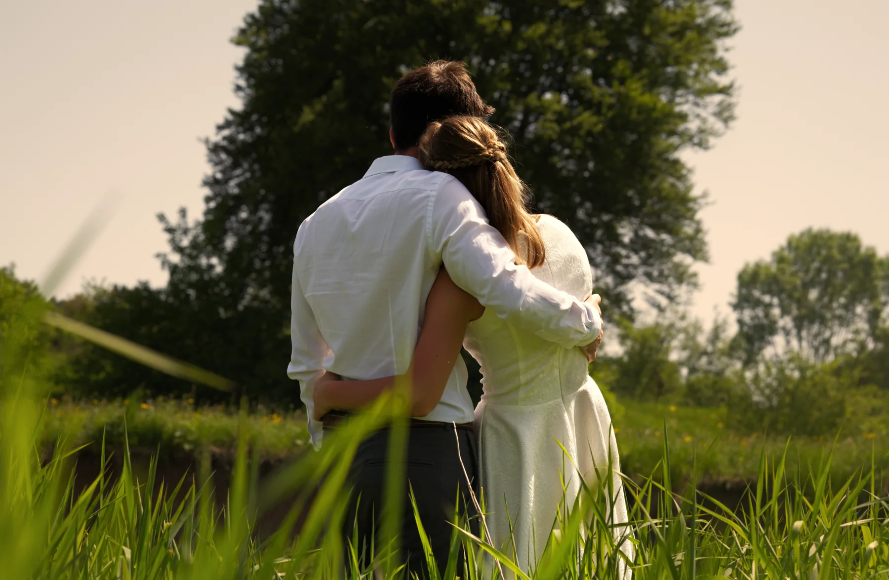 Scarlett und David stehen Arm in Arm auf einer Wiese