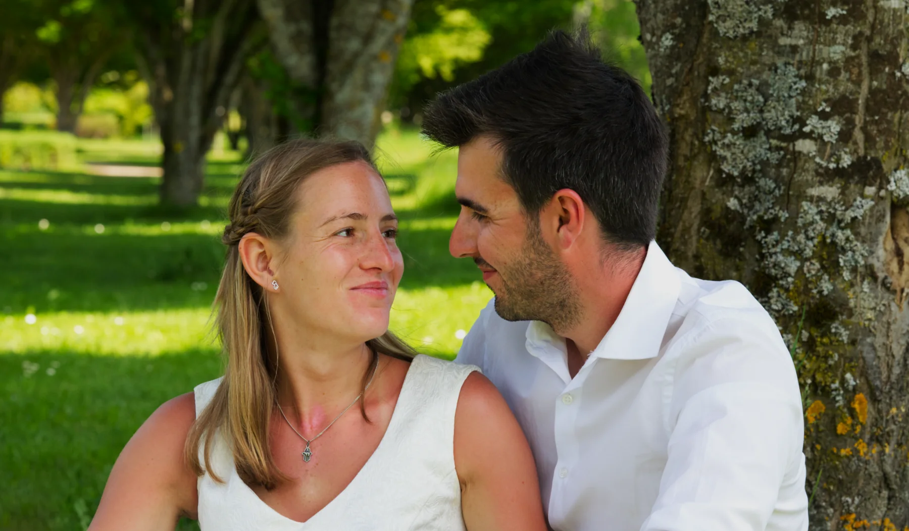 Scarlett und David sitzen zusammen an einem Baum